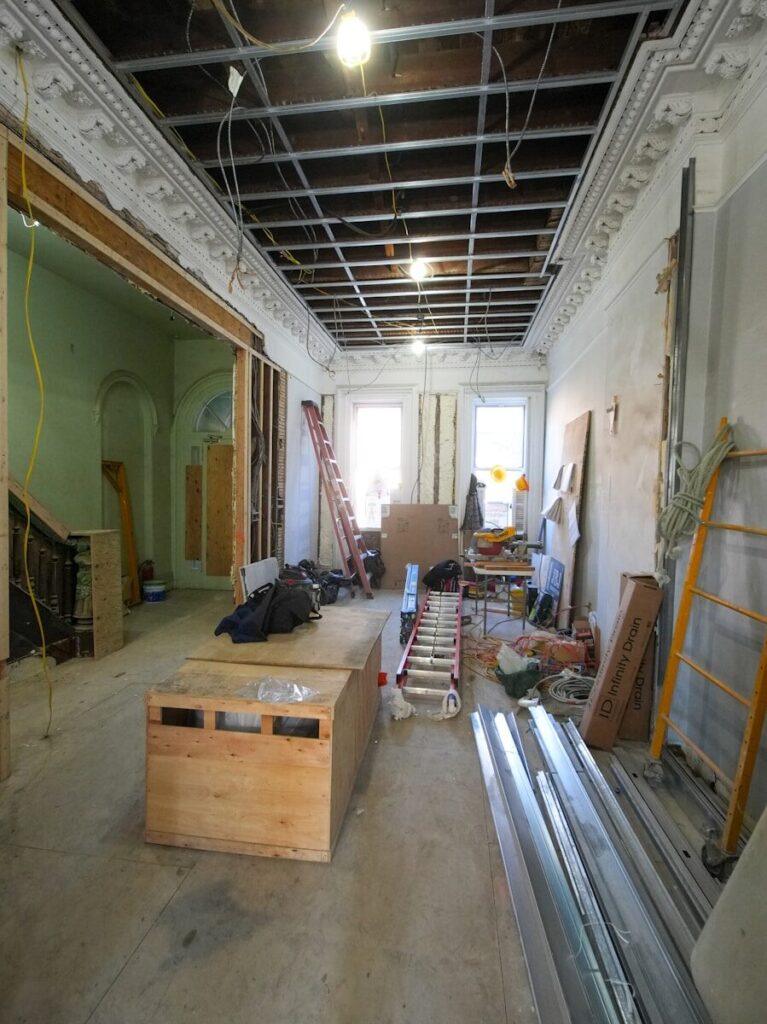 Interior room undergoing renovation with exposed ceiling and materials.