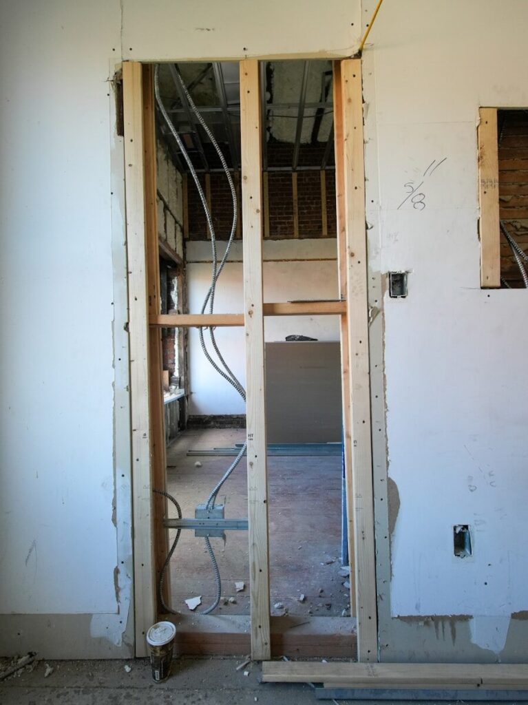 Interior doorway under construction with exposed wiring.